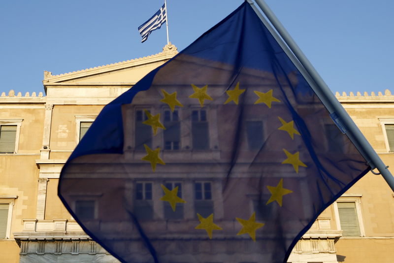 © Reuters. A protester waves a Greek flag during a demonstration outside the parliament building in central Athens