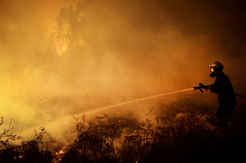 &copy; Reuters.  Bushfires destroy buildings in Australia as heatwave melts highway surface