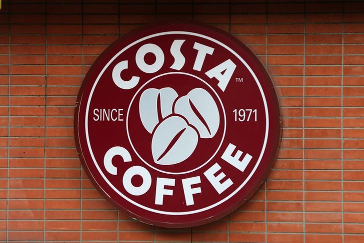 © Reuters. FILE PHOTO: A worker walks above a Costa Coffee under going maintenance work in Loughborough