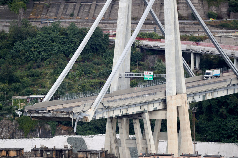 © Reuters. Una donna manifesta a un mese dal crollo del ponte Morandi a Genova