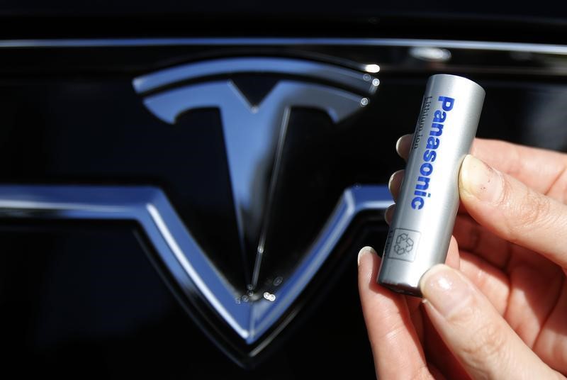 © Reuters. Bateria automotiva da Panasonic diante de logo da montadora elétrica, Tesla, em Tóquio, Japão