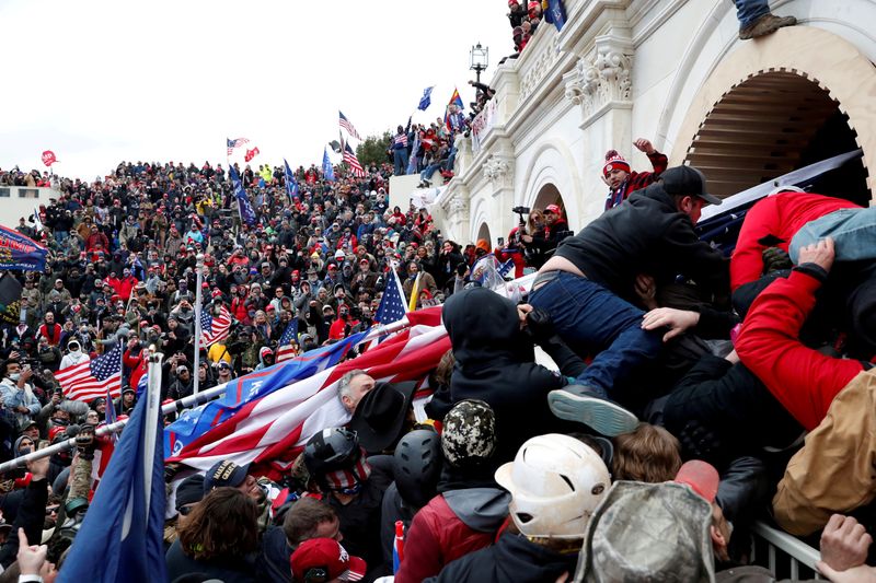© Reuters. FILE PHOTO: A mob of supporters of then-U.S. President Donald Trump climb through a window they broke as they storm the U.S. Capitol Building in Washington, U.S., January 6, 2021. REUTERS/Leah Millis/File Photo
