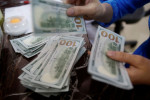 Dólar sobe puxado por exterior com mercado à espera de novidades sobre tarifaço