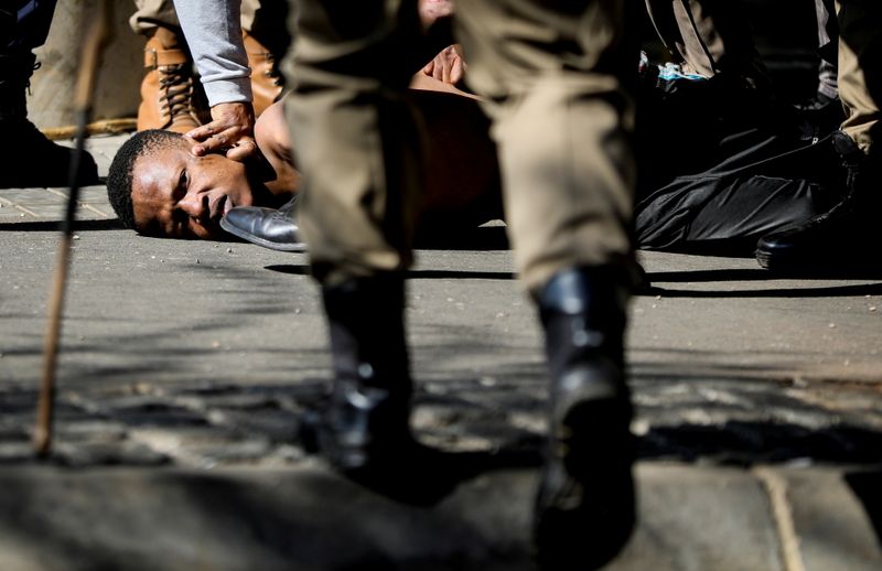 © Reuters. الشرطة تلقي القبض على أحد المحتجين على سجن الرئيس الجنوب افريقي السابق جاكوب زوما في جوهانسبرج يوم الاحد. تصوير: سمية هشام - رويترز.