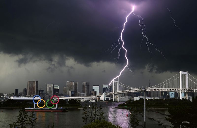 &copy; Reuters. A lightening is seen over the giant Olympic rings and the Rainbow Bridge from the waterfront area of Odaiba Marine Park, ahead of the opening of the 2020 Tokyo Olympic Games, that have been postponed to 2021 due to the coronavirus disease (COVID-19) outbr