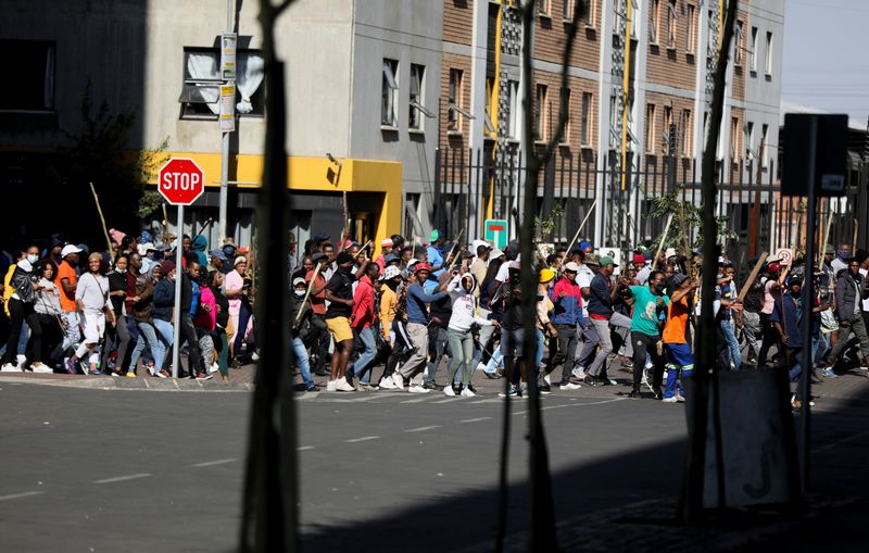 &copy; Reuters. FILE PHOTO: Stick-wielding protesters march through the streets as violence following the jailing of former South African President Jacob Zuma spread to the country's main economic hub in Johannesburg, South Africa, July 11, 2021. REUTERS/Sumaya Hisham