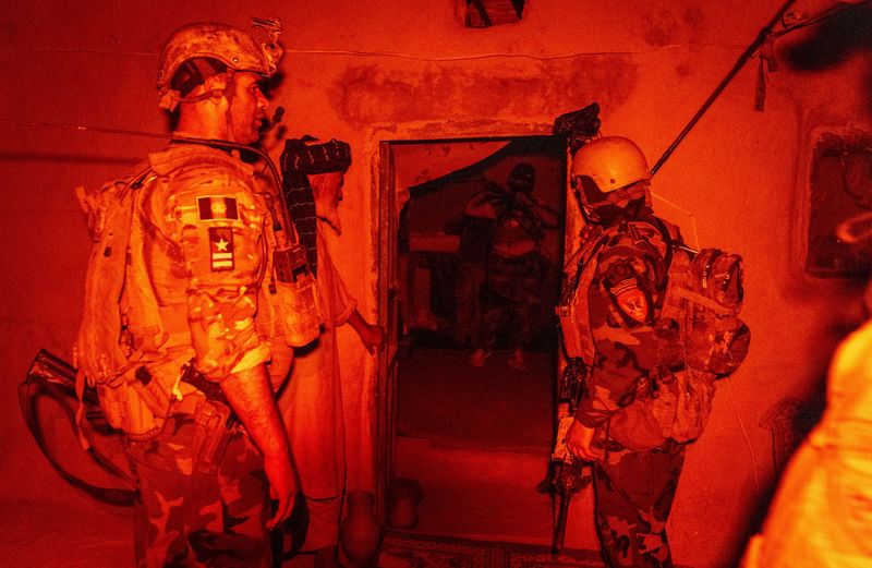 © Reuters. A member of the Afghan Special Forces speaks to a resident as others search his house during a mission against Taliban, in Kandahar province, Afghanistan, July 12, 2021. REUTERS/Danish Siddiqui