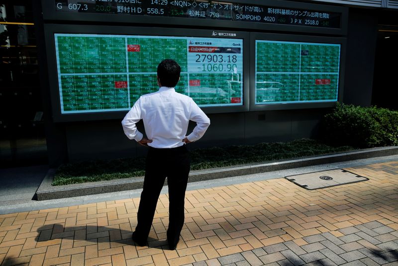 &copy; Reuters. FILE PHOTO: A man watches an electric board showing Nikkei index outside a brokerage at a business district in Tokyo, Japan, June 21, 2021.   REUTERS/Kim Kyung-Hoon/Files