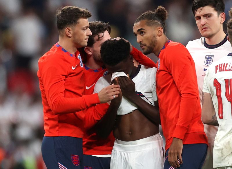 &copy; Reuters. Bukayo Saka é consolado por colegas de time após derrota da Inglaterra para a Itália na final da Eurocopa em Wembley
11/07/2021 Pool via REUTERS/Carl Recine