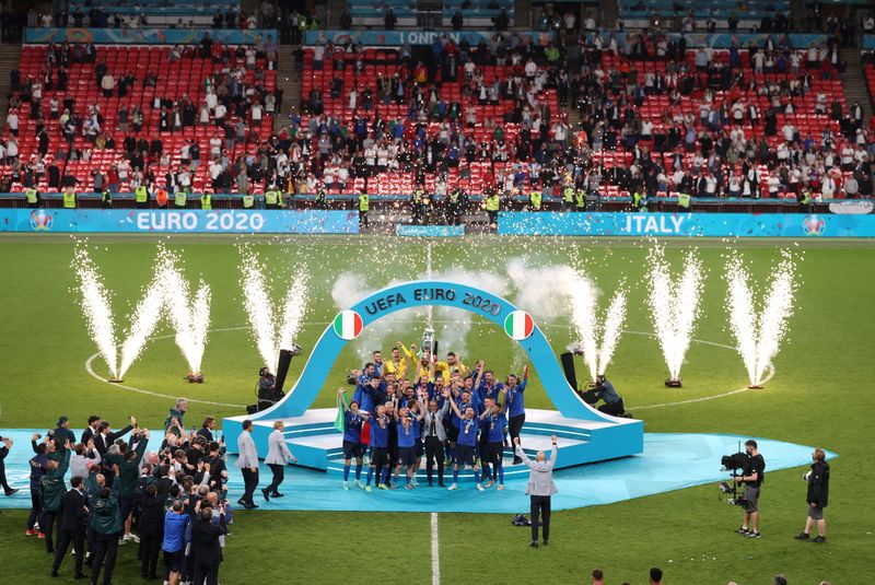 &copy; Reuters. Jogadores da seleção da Itália comemoram conquista da Eurocopa com troféu no pódio em Wembley
11/07/2021 Pool via REUTERS/Catherine Ivill