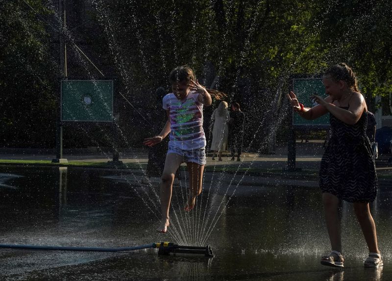 &copy; Reuters. Crianças brincam com água em meio a forte calor em zoológico de Moscou
12/07/2021 REUTERS/Tatyana Makeyeva