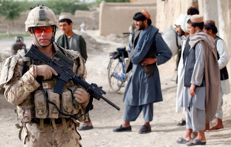 &copy; Reuters. جندي كندي يوفر الحماية لموظفي المعونة في قرية لوي بالا كرز جنوب شرقي قندهار في أفغانستان يوم الاثنين. تصوير: نيكولا سوليتش - رويترز.