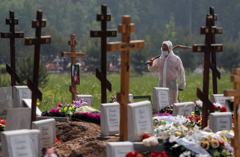 &copy; Reuters. A grave digger wearing personal protective equipment (PPE) walks after burying a person, who presumably died of the coronavirus disease (COVID-19) in the special purpose section of a graveyard on the outskirts of Saint Petersburg, Russia June 10, 2020.  R