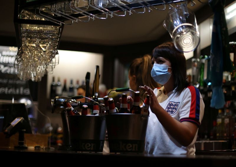 &copy; Reuters. FILE PHOTO: Soccer Football - Euro 2020 - Fans gather ahead of Ukraine v England - The Thistleberry pub, Newcastle-under-Lyme, Britain - July 3, 2021 Bar staff serving drinks before the match Action Images via Reuters/Carl Recine/File Photo