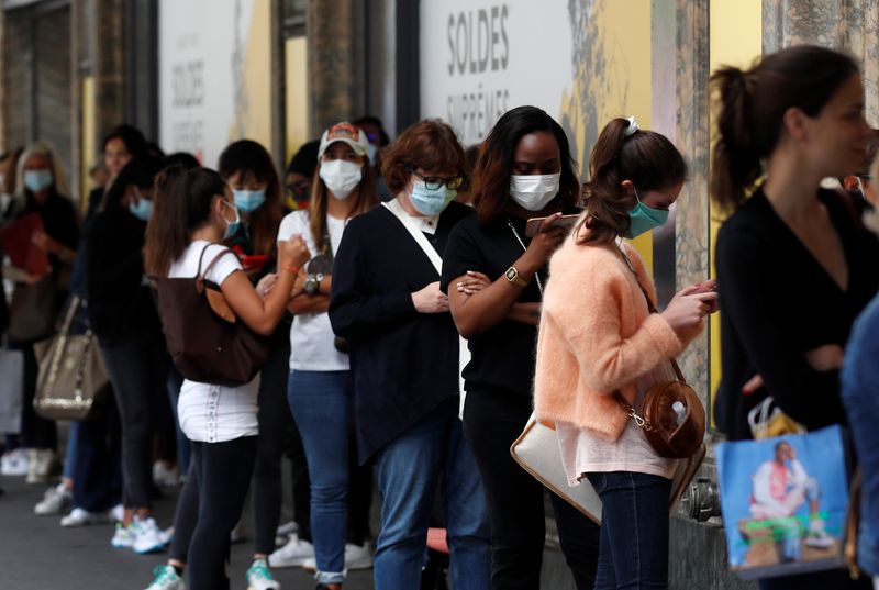 &copy; Reuters. FILE PHOTO: People wearing protective face masks wait before the opening of the department store Le Printemps Haussmann in Paris on the first day of summer sales following the outbreak of the coronavirus disease (COVID-19) in France, July 15, 2020.  REUTE