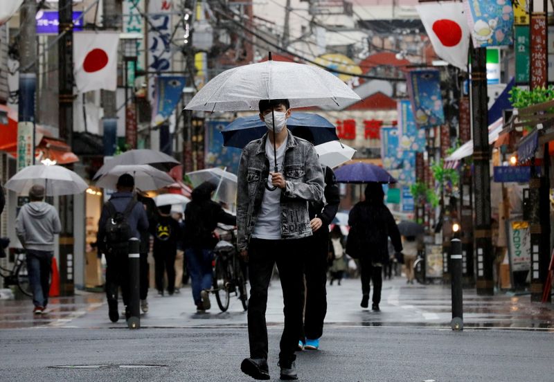 &copy; Reuters. FILE PHOTO: A man wearing a protective face mask, amid the coronavirus disease (COVID-19) pandemic, makes his way at a local shopping street in Tokyo, Japan, May 5, 2021. REUTERS/Kim Kyung-Hoon