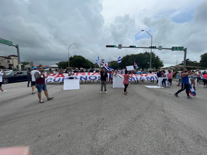 © Reuters. People hold flags, signs and a banner on the Palmetto Expressway following reports of protests in Cuba against its deteriorating economy, in Miami, Florida, July 13, 2021, in this image obtained via social media. INSTAGRAM @STANDFORCUBA via REUTERS