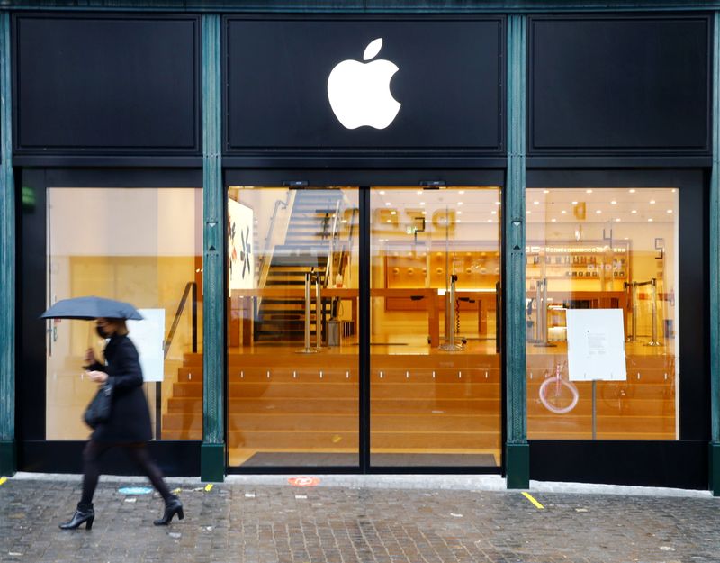 &copy; Reuters. FILE PHOTO: A person walks past an Apple store, which is closed during a partial lockdown, as the spread of the coronavirus disease (COVID-19) continues, in Zurich, Switzerland January 28, 2021. REUTERS/Arnd Wiegmann