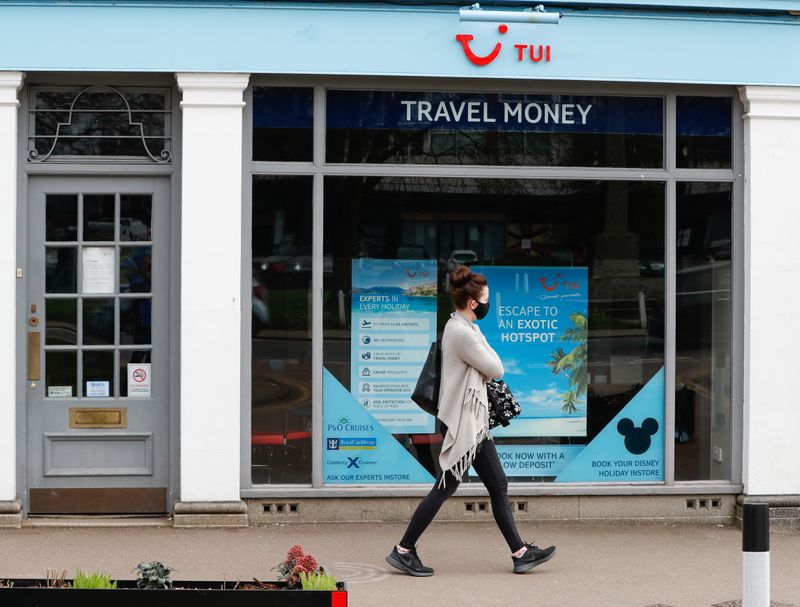 &copy; Reuters. FILE PHOTO: A woman walks past the TUI travel centre, amid the coronavirus disease (COVID-19) outbreak, in Harpenden, Britain, March 24, 2021. REUTERS/Paul Childs