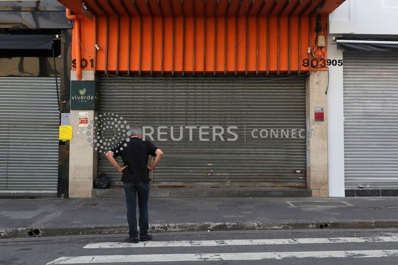 &copy; Reuters. Homem parado em frente a lojas fechadas no centro de São Paulo depois que  autoridades decretaram o fechamento do comércio como medida de precaução contra o coronavírus no ano passado
20/03/2020 REUTERS/Amanda Perobelli