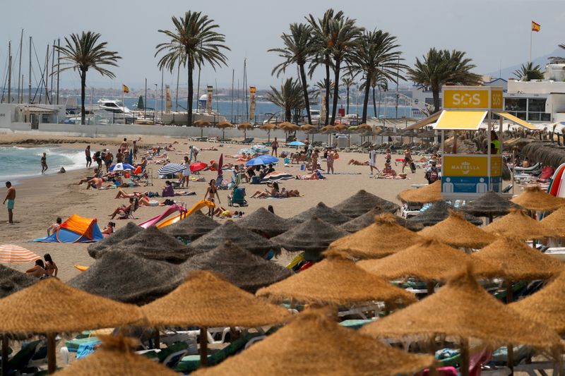 &copy; Reuters. FILE PHOTO: People cool off on a beach, amid the coronavirus disease (COVID-19) pandemic, in Marbella, Spain July 9, 2021. REUTERS/Jon Nazca