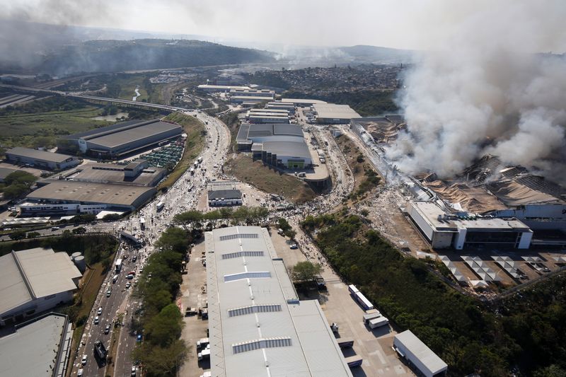 &copy; Reuters. FILE PHOTO: A general view of the burning warehouse after violence erupted following the jailing of former South African President Jacob Zuma, in Durban, South Africa, July 14, 2021. REUTERS/Rogan Ward