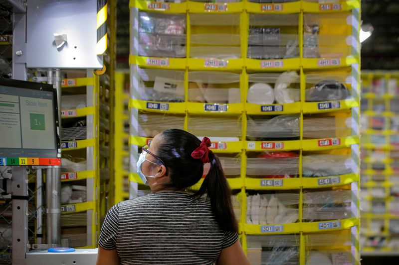 &copy; Reuters. FILE PHOTO: An employee fills a cart full of items at Amazon's JFK8 distribution center in Staten Island, New York, U.S. November 25, 2020.  REUTERS/Brendan McDermid./File Photo