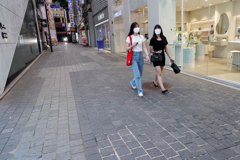 &copy; Reuters. FILE PHOTO: Women walk on an empty street amid tightened social distancing rules due to the coronavirus disease (COVID-19) pandemic in Seoul, South Korea, July 12, 2021. REUTERS/Heo Ran