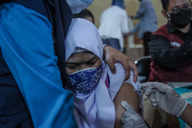 &copy; Reuters. A student reacts as she receives a vaccine against the coronavirus disease (COVID-19) during a mass vaccination program for students as COVID-19 cases surge, in Bandung, West Java Province Indonesia July 14, 2021. Antara Foto/Raisan Al Farisi/via REUTERS 