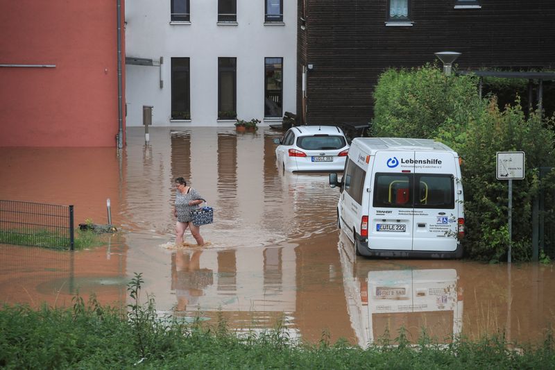 &copy; Reuters. Una mujer camina por el agua de la inundación tras las fuertes lluvias en Gross-Vernich, Alemania, 15 de julio de 2021. REUTERS/Wolfgang Rattay