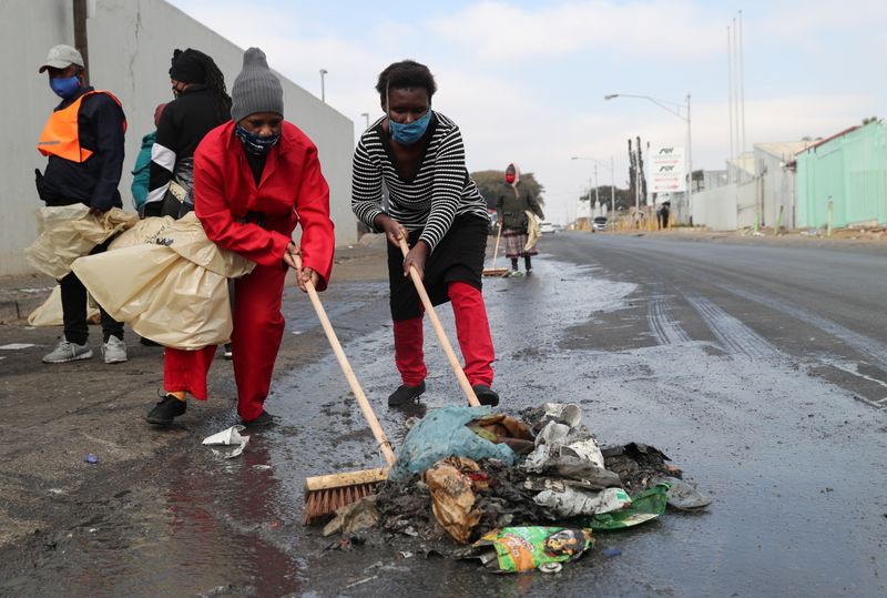 &copy; Reuters. سكان ينظفون الشوارع بعد الاحتجاجات والاضطرابات المرتبطة بسجن الرئيس السابق جاكوب زوما في الكسندرا بجنوب أفريقيا يوم الخميس. تصوير: سمية هش