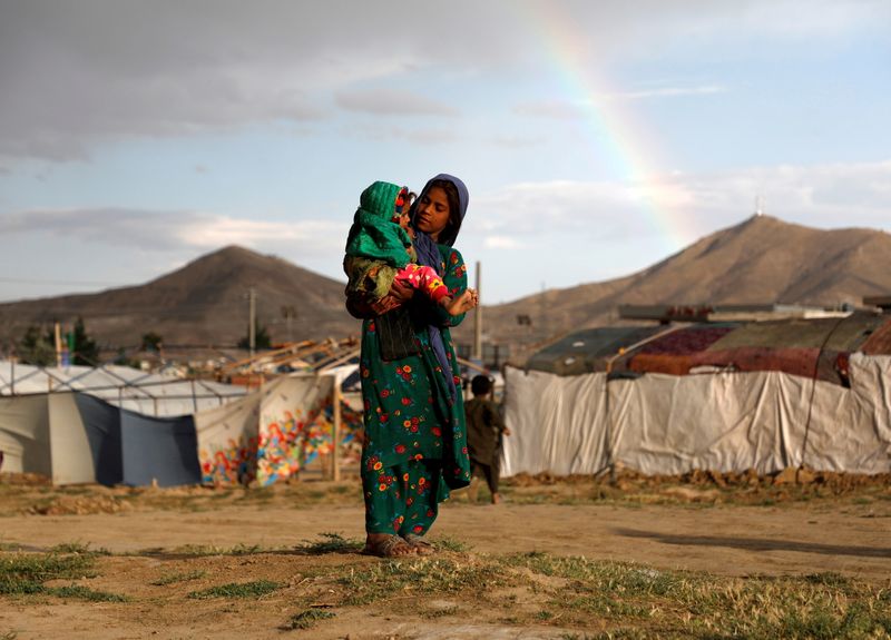 &copy; Reuters. Menina afegã deslocada pela guerra carrega criança perto do abrigo em que vive em um campo de refugiados nos arredores de Cabul
20/06/2019 REUTERS/Omar Sobhani