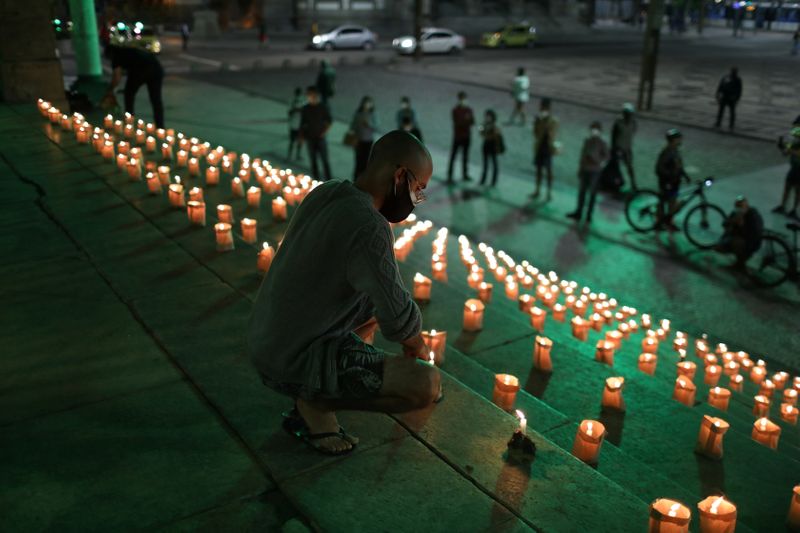 &copy; Reuters. Pessoas acendem velas no Rio de Janeiro em homenagem aos mortos pela Covid-19
21/06/2021 REUTERS/Pilar Olivares