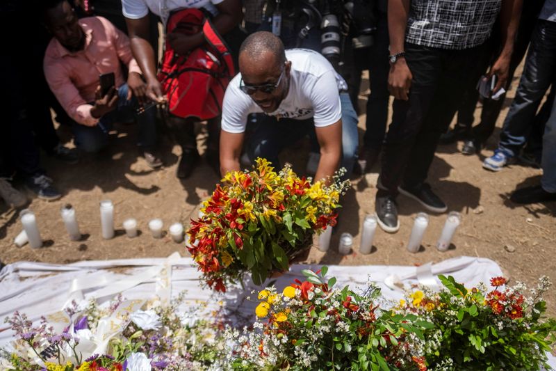 &copy; Reuters. Foto del miércoles de un hombre dejando flores fuera del Palacio Presidencial en honor al asesinado presidente de Haití, Jovenel Moise, una semana después de su muerte. 
Jul 14, 2021. REUTERS/Ricardo Arduengo