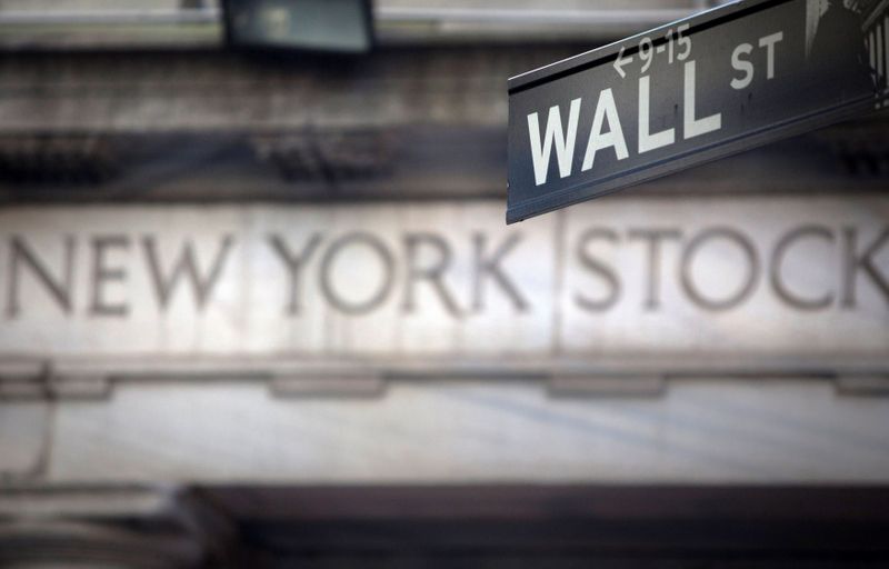 &copy; Reuters. Un cartello stradale di Wall Street davanti all'insegna della Borsa di New York.  REUTERS/Carlo Allegri