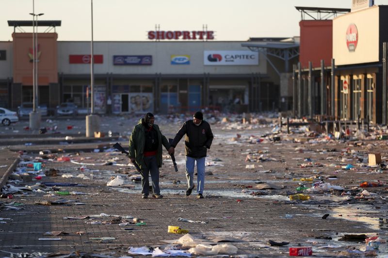 &copy; Reuters. FILE PHOTO: Members of a private security walk at a looted shopping mall as the country deploys army to quell unrest linked to the jailing of former South African President Jacob Zuma, in Vosloorus, South Africa, July 14, 2021. REUTERS/Siphiwe Sibeko