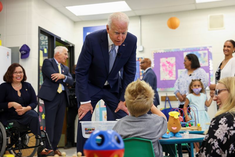 &copy; Reuters. FILE PHOTO: U.S. President Joe Biden flanked by President of McHenry County College Clint Gabbard and Senator Tammy Duckworth, speaks with a child, as he tours the Children's Learning Center at McHenry County College during a visit to the northwest Chicag