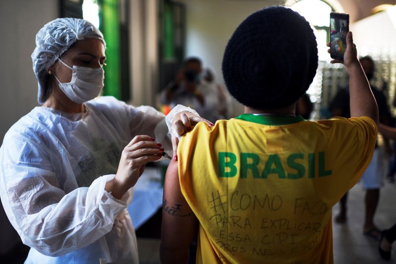 &copy; Reuters. Imagen de archivo de una enfermera aplicando una dosis de la vacuna de Johnson & Johnson contra el coronavirus a una persona mientras se toma una autofoto en Ilha Grande, Brasil. 10 julio 2021. REUTERS/Lucas Landau