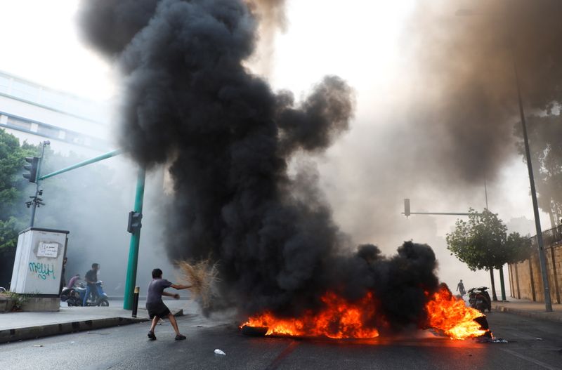 © Reuters. أنصار الحريري يشعلون النار في اطارات مركبات في بيروت يوم الخميس. تصوير: محمد عزاقير - رويترز.