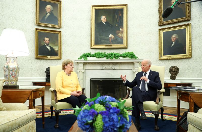 &copy; Reuters. ７月１５日、バイデン米大統領（右）は、ホワイトハウスでドイツのメルケル首相（左）と会談し、ロシアとドイツを結ぶガスパイプライン「ノルドストリーム２」への懸念を伝えた（２０