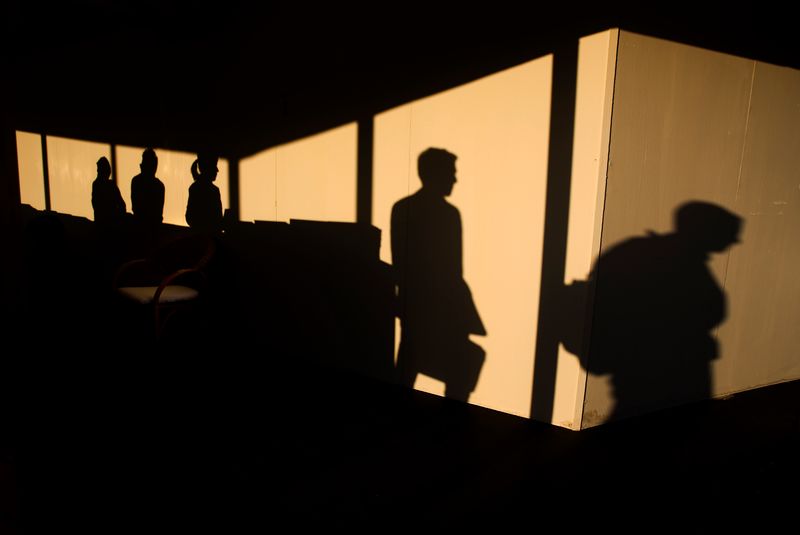 &copy; Reuters. Shadows are cast as members of the press pass an information desk at the media centre during the G8 summit in L'Aquila Italy July 8, 2009.   Picture taken July 8, 2009  REUTERS/Kevin Coombs   (ITALY)
