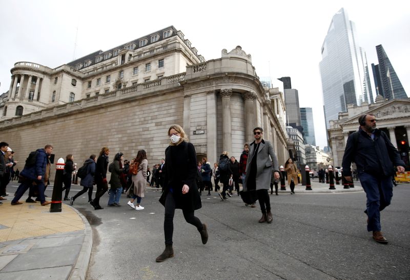 &copy; Reuters. FILE PHOTO: A woman wearing a protective face mask, following an outbreak of the coronavirus, walks in front of the Bank of England in London, Britain March 11, 2020. REUTERS/Henry Nicholls
