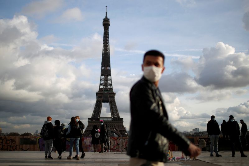 &copy; Reuters. رجل يضع كمامة يسير أمام برج إيفل في باريس بصورة من أرشيف رويترز.