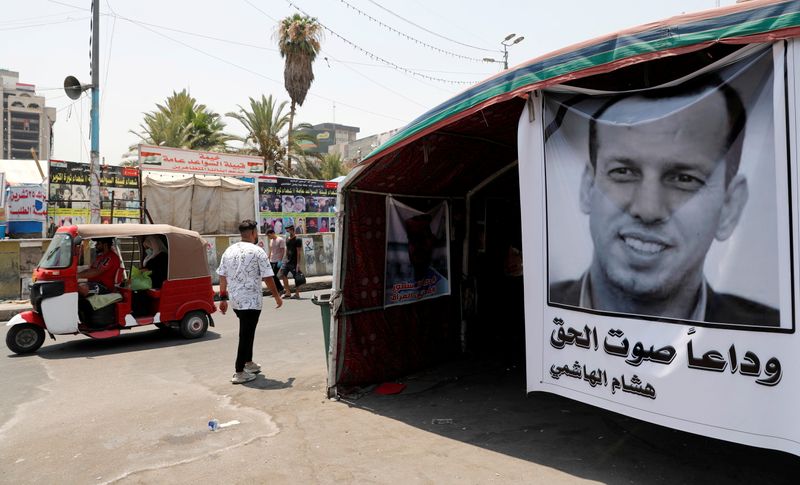 &copy; Reuters. ملصق للمستشار الحكومي الراحل هشام الهاشمي في بغداد يوم الثامن من يوليو تموز 2021. تصوير: ثائر السوداني - رويترز. 