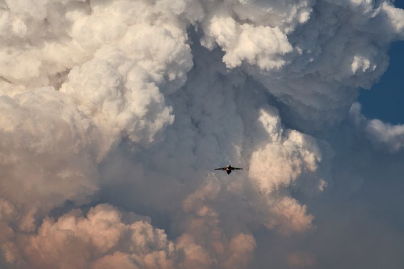 &copy; Reuters. A firefighting aircraft returns to base amid massive plumes of smoke after dropping flame-retarding chemicals on the Bootleg Fire, as it expands to over 225,000 acres, in Bly, Oregon, U.S., July 15, 2021. REUTERS/Mathieu Lewis-Rolland    