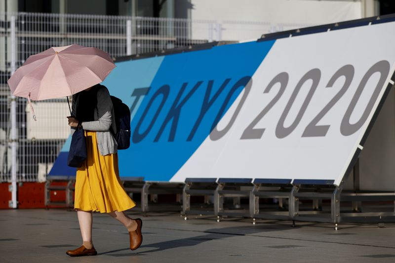 &copy; Reuters. A woman walks past Tokyo 2020 Olympic Games signage at the Main Press Center during the coronavirus disease (COVID-19) outbreak in Tokyo, Japan, July 16, 2021.  REUTERS/Thomas Peter