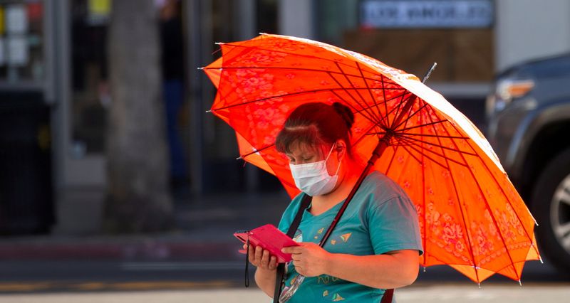 &copy; Reuters. FILE PHOTO: A person wearing a protective face mask uses her mobile phone during the outbreak of the coronavirus disease (COVID-19), in Los Angeles, California, U.S., March 31, 2021.  REUTERS/Mario Anzuoni/File Photo