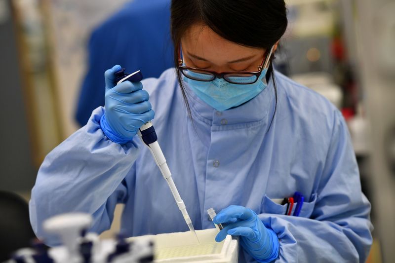 &copy; Reuters. FILE PHOTO: Scientists work at a laboratory where they sequence the novel coronavirus genomes at COVID-19 Genomics UK, on the Wellcome Sanger Institute's 55-acre campus south of Cambridge, Britain March 12, 2021. Picture taken March 12, 2021.  REUTERS/Dyl