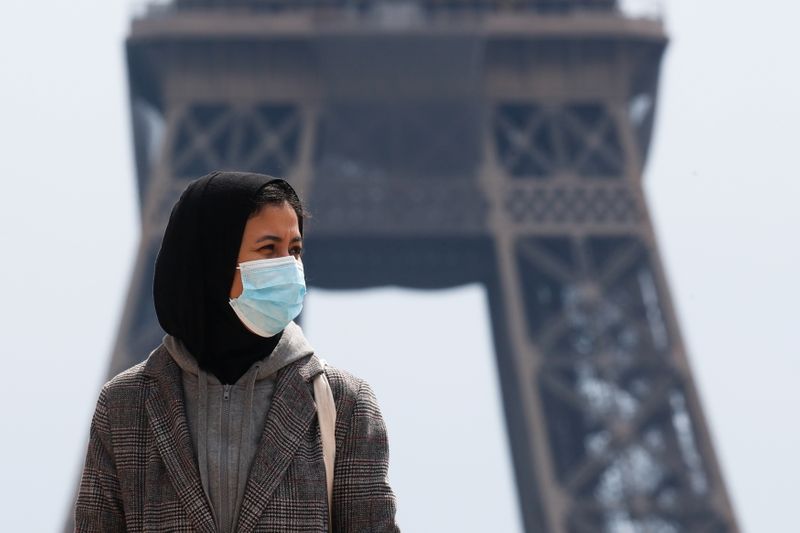 &copy; Reuters. امرأة تضع كمامة للوقاية من فيروس كورونا باقرب من برج إيفل في باريس يوم الثاني من مايو ايار 2021. تصوير: جونزالو فوينتس - رويترز. 