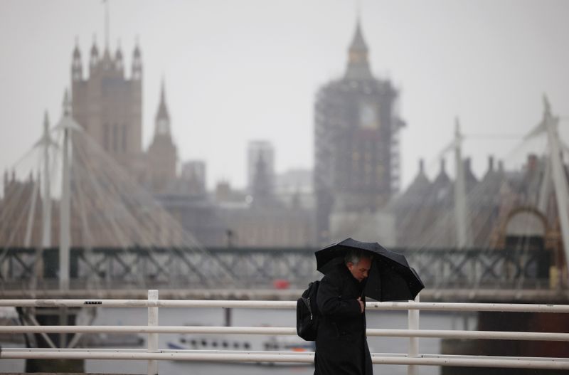 &copy; Reuters. FILE PHOTO: A man holding an umbrella walks over Waterloo Bridge during rainfall, amid the coronavirus disease (COVID-19) outbreak, in London, Britain, March 12, 2021.  REUTERS/Henry Nicholls